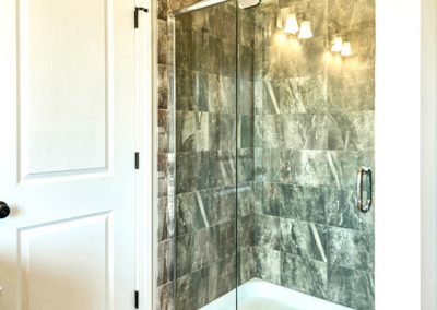 tiled shower with clear glass door