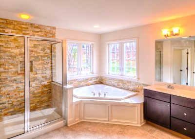shower corner tub with stone wall and double vanity