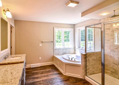 multi level vanity with oval tub and tiled shower