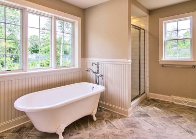 custom claw foot tub with window and subway tiled shower