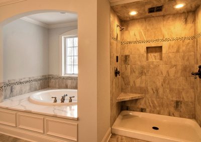 custom arched bath tub enclosure and large tiled shower