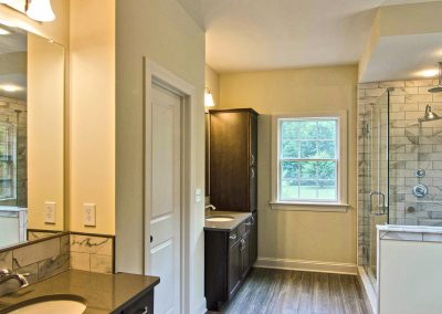 two single vanities with custom marble tile shower