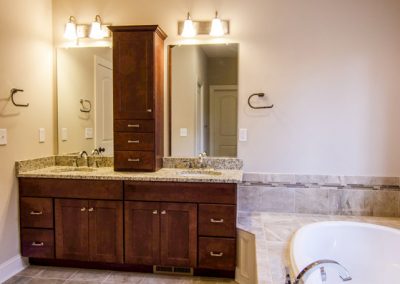 double vanity with upper cabinet and oval tub