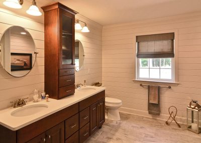 decorative walls with double vanity with upper cabinet and round mirrors