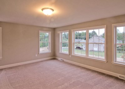 carpeted bedroom with lots of windows