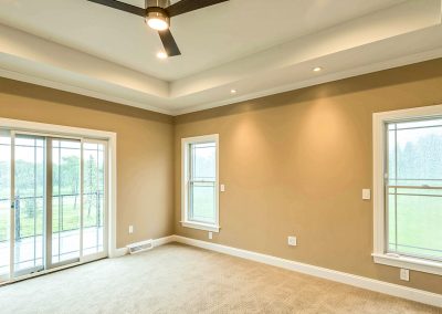 custom bedroom with tray ceiling and fan