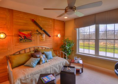 bedroom with decorative wood wall and ceiling fan
