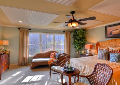 furnished bedroom with decorative ceiling and fan