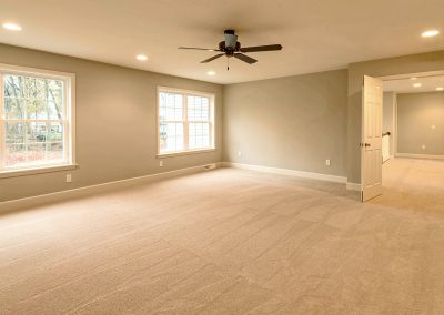 large carpeted bedroom with ceiling fan