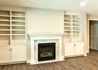 built in shelving and cabinets either side of fireplace