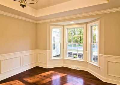 dining room with wall molding tray ceiling and bay window