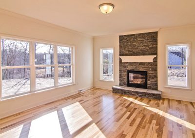 family room with stone fierplace and hardwood flooring
