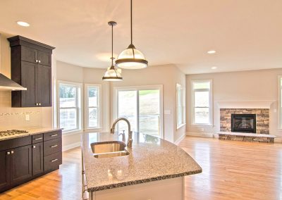 open plan kitchen dining and living with stone fireplace