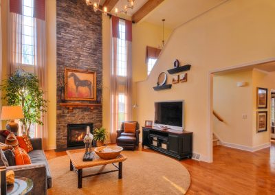 furnished two story family room with stone fireplace