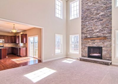 two story room with stone fireplace