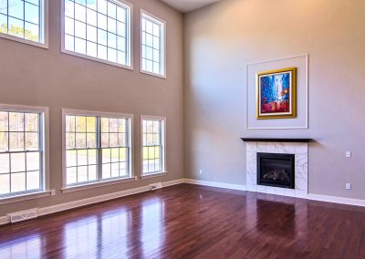 two story room with windows and fireplace