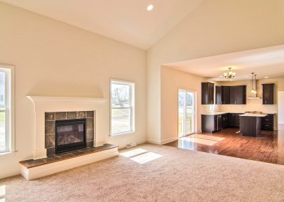 carpeted family room with raised tiled hearth