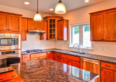 cherry kitchen with double ovens and glass corner cabinet