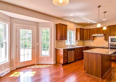 dark kitchen with bay windows and door