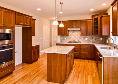 dark kitchen with island and wall oven