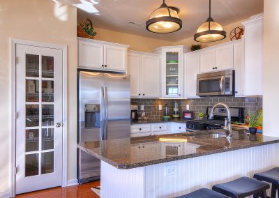 small white condo kitchen with glass door pantry