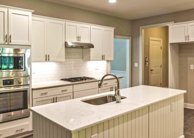white kitchen with wall oven and island