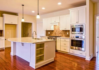 open plan white kitchen with curved island countertop
