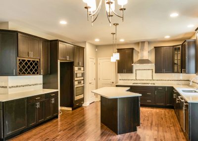 dark kitchen with angled island and end cabinets