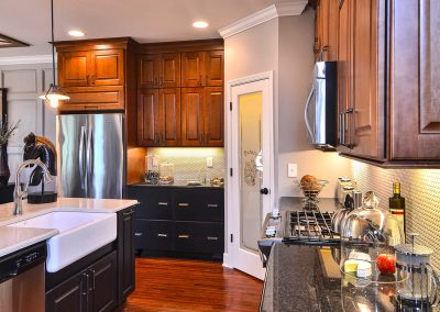 dark kitchen with drawer cabinets and farmhouse sink