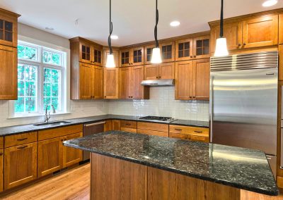 cherry kitchen with tall upper cabinets and dark counters